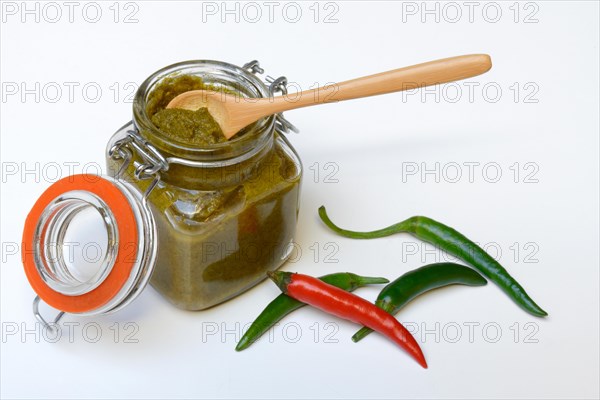 Green Thai curry paste in jar and chillies