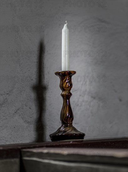 Candlestick with white candle in a church
