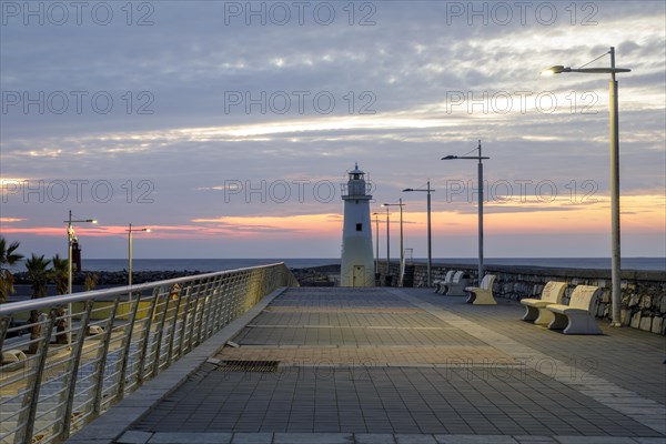 Sunrise with lighthouse at the harbour pier in Porto Maurizio