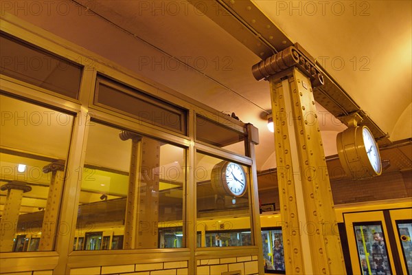 Clock reflected in a pane and steel girders of the underground station Klosterstrasse