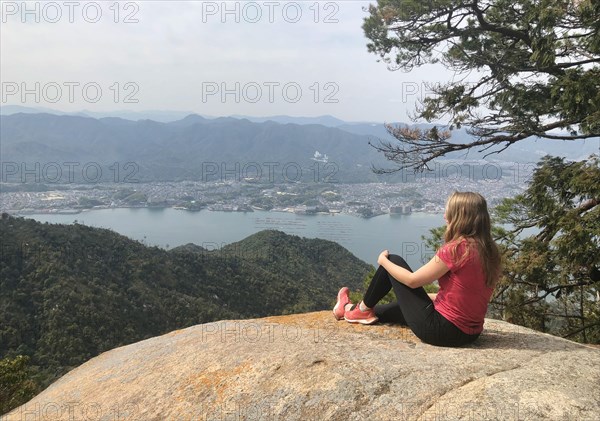 Young woman sitting on a stone