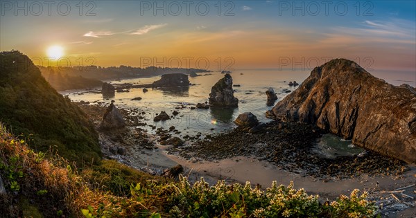 View of sea and sandy beach Harris Beach with rocks at sunrise