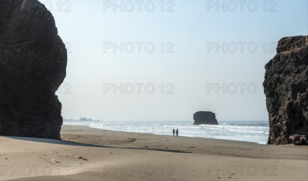 People on the beach between big rocks
