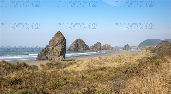 View over sandy beach with dunes and large rocks