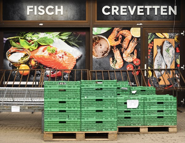 Shop window fish Crevetten in front of it green plastic boxes