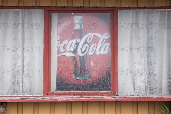 Old advertising sign for Coca-Cola in window