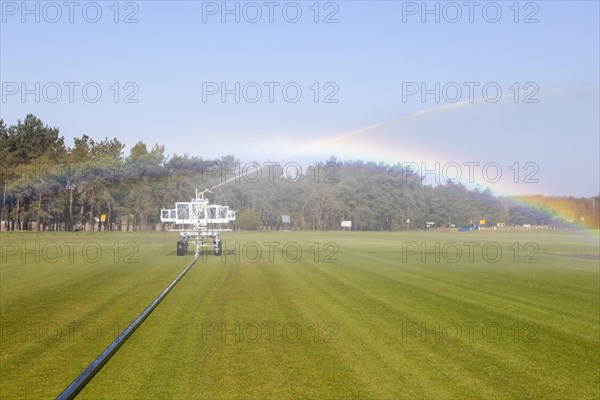 Irrigator machine spraying water turf farming