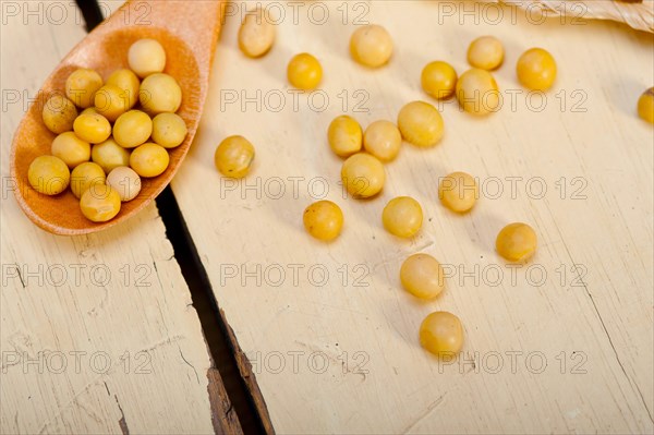 Organic soya beans over rustic wood table macro closeup