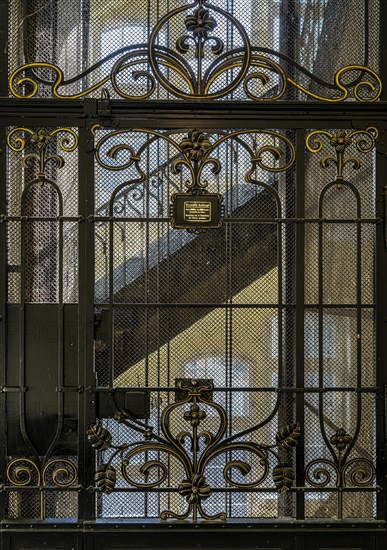 Decorated door and warning sign from a historic lift in an old factory
