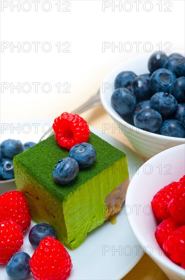 Green tea matcha mousse cake with raspberries and blueberries on top
