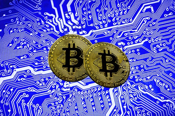 Bitcoin BTC crypto currency gold coins on a mainboard