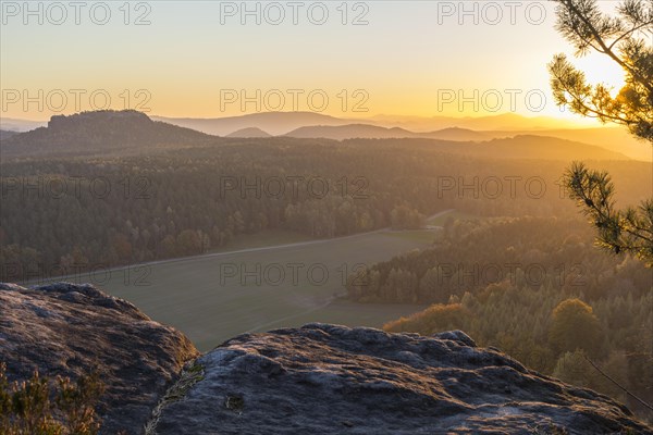 Rocks and vantage point on Pfaffenstein with view of Table Mountain Gohrisch at sunrise
