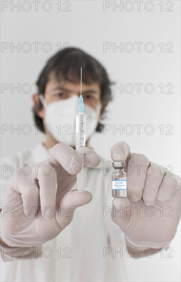 Doctor holding a vaccine bottle and syringe