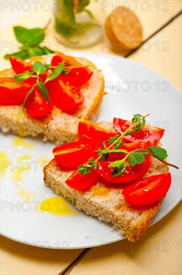 Italian tomato bruschetta with thyme and mint leaves