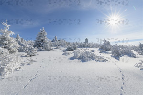 Snow covered winter landscape with sun Fichtelberghaus and weather station