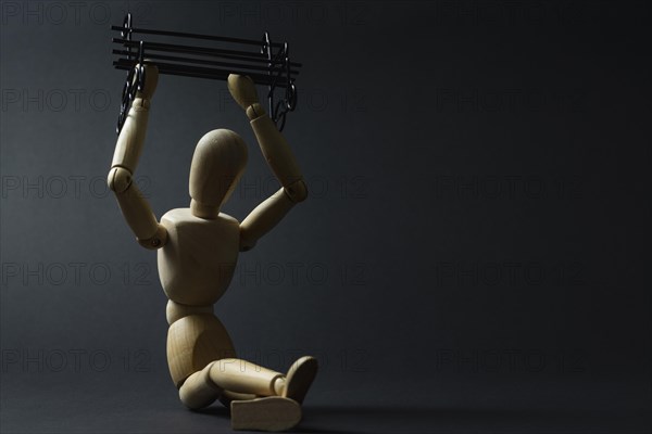 The mannequin holds a bench in its hands
