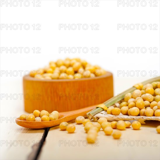 Organic soya beans over rustic wood table macro closeup