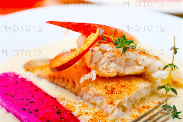 Sea bream orata fillet butter pan fried with fresh peach prune and dragonfruit slices thyme on top