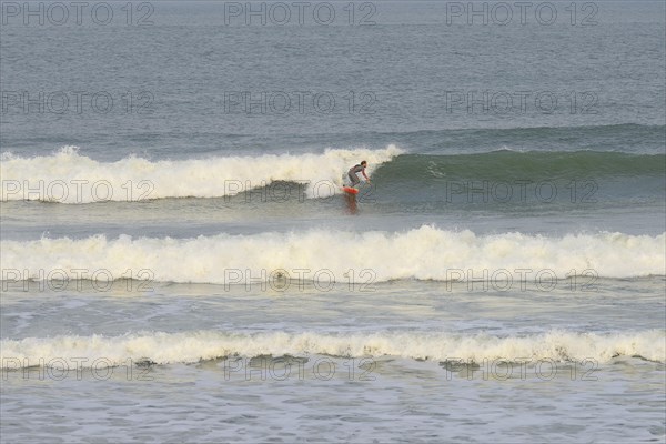 Surfer riding the wave at Praia de Mocambique
