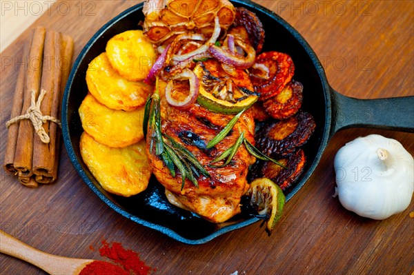 Roasted grilled BBQ chicken breast with herbs and spices rustic style on iron skillet