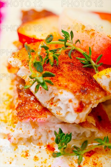 Sea bream orata fillet butter pan fried with fresh peach prune and dragonfruit slices thyme on top