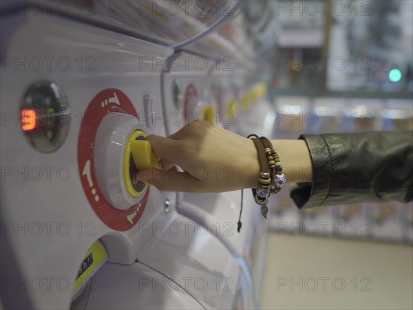 Hand using toy vending machine
