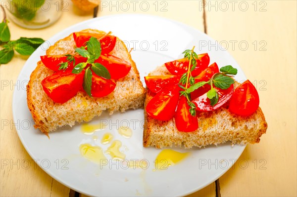 Italian tomato bruschetta with thyme and mint leaves