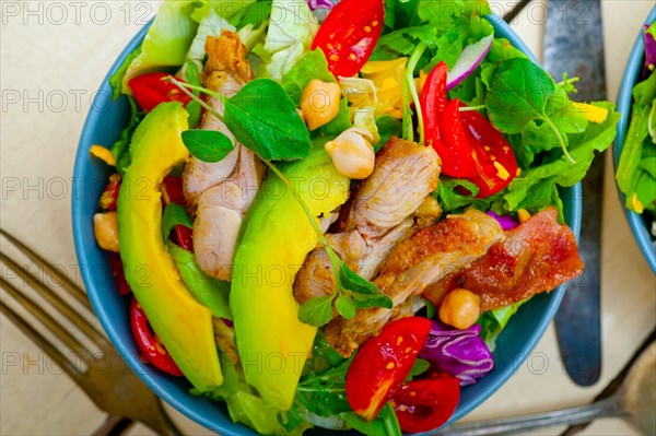 Fresh and healthy Chicken Avocado salad over rustic wood table