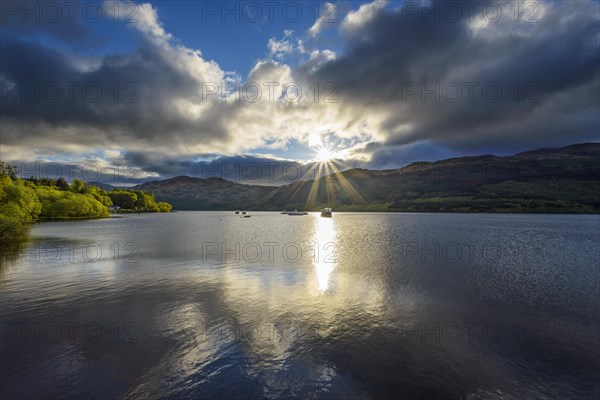 Lake with dramatic clouds and sun in spring