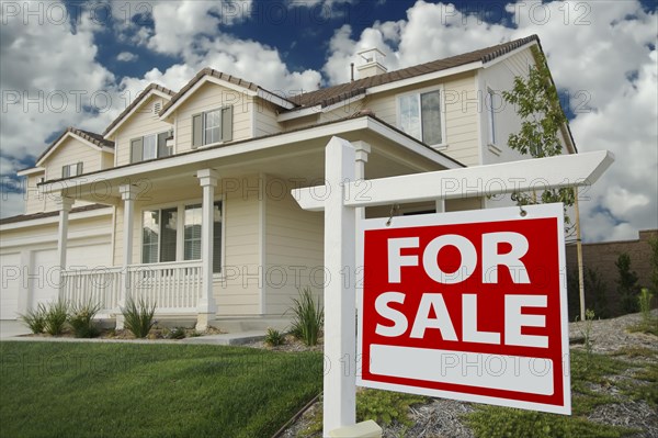 Home for sale sign in front of beautiful new home