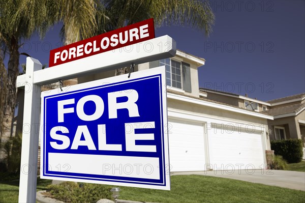 Foreclosure for sale real estate sign in front of house