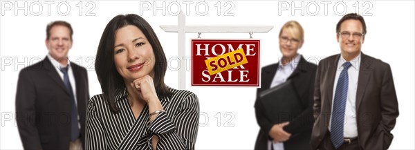 Pretty hispanic woman and other people behind in front of sold home for sale real estate sign isolated on a white background