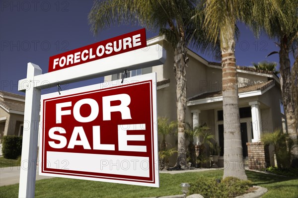 Foreclosure for sale real estate sign in front of house