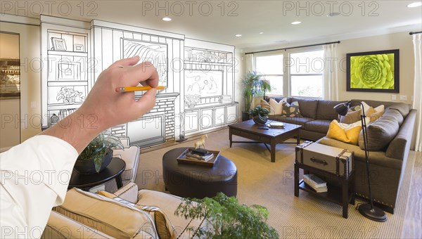 Male hand drawing entertainment center unit over photo of beautiful home interior