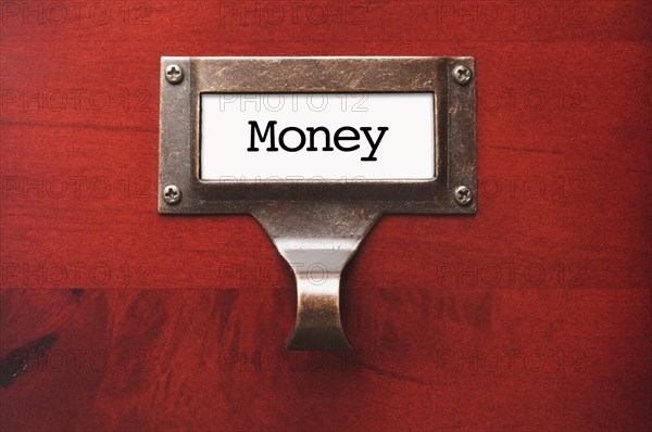 Lustrous wooden cabinet with money file label in dramatic light