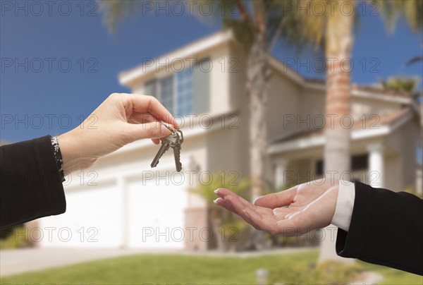 Handing over the new house keys with home in the background