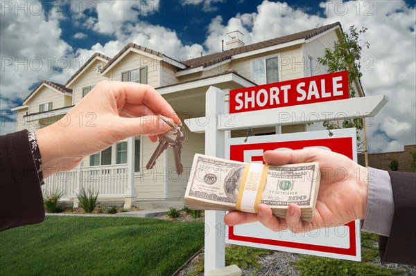 Handing over cash for house keys and short sale real estate sign in front of home