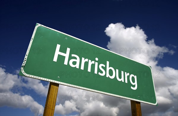 Harrisburg road sign with dramatic blue sky and clouds