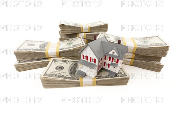 Small house with stacks of hundred dollar bills isolated on a white background