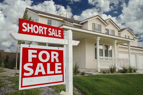 Short sale home for sale real estate sign and house