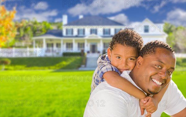 Happy playful african american father and mixed-race son in front of house