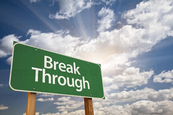 Break through green road sign with dramatic clouds and sky