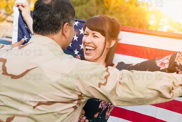 Excited woman with american flag runs to male military soldier returning home