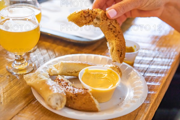 Woman enjoys warm pretzels and micro brew beer