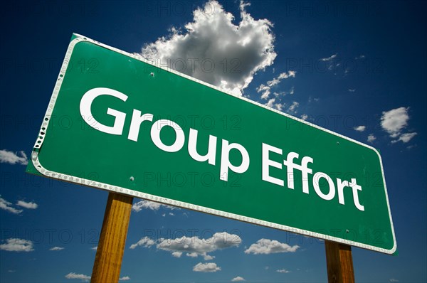 Group effort green road sign with dramatic clouds and sky