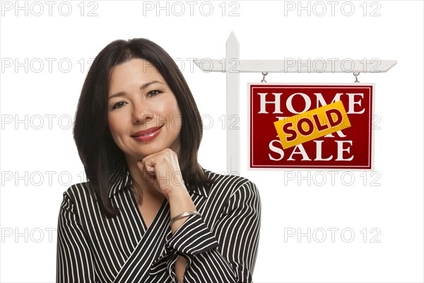 Ethnic woman in front of sold home for sale real estate sign isolated on a white background