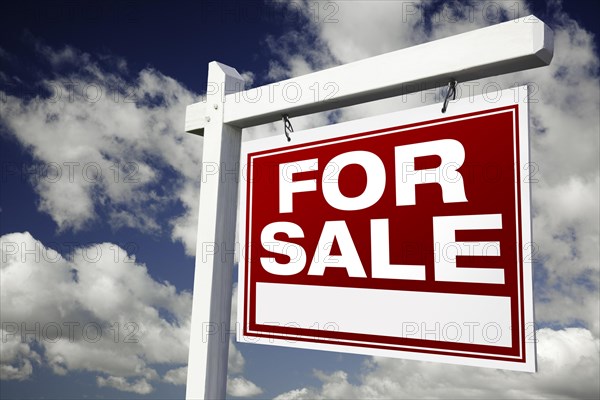 For sale real estate sign on clouds & sky background