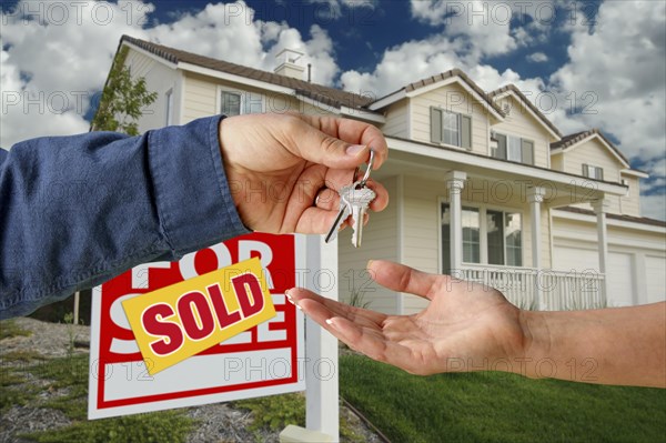 Handing over the keys to A new home with sold home for sale sign