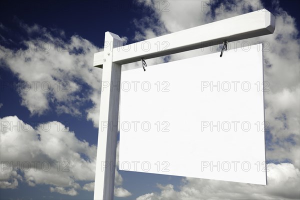 Blank real estate sign on clouds & sky background