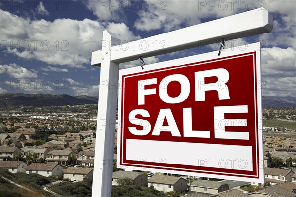 For sale real estate sign with elevated housing community view